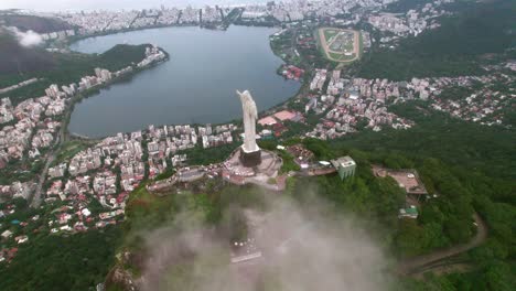 Aerial-Orbiting-shot-of-Christ-the-Redeemer-with-the-Rodrigo-de-Freitas-lagoon-in-the-background,-Rio-de-Janeiro