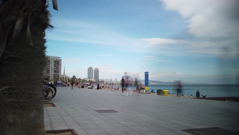 People-Walk-at-Barceloneta-Beach-Barcelona-Spain-Time-Lapse-Shot,-Sea,-Skyline-in-Summer