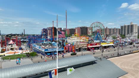 An-Aerial-orbiting-shot-of-the-American-flag-and-Pow-Mia-flag-at-the-Coney-Island-amusement-park-boardwalk-over-the-beach-in-New-York-city