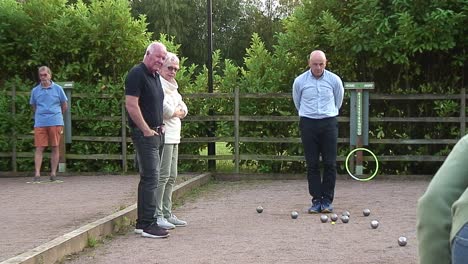 Three-male-pétanque-players-seeing-who-were-closest-to-the-cochon-with-their-steel-boules-at-a-league-game