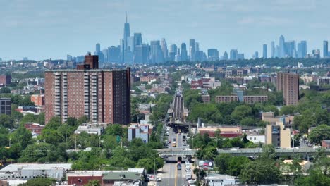 Ein-Schwenk-über-Brooklyn-Mit-Blick-Auf-Die-Skyline-Von-New-York,-Während-Dichter-Verkehr-Eine-Brücke-Darunter-überquert