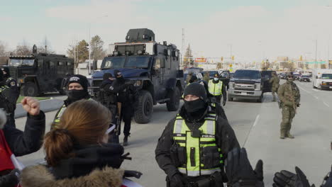 Large-military-vehicles-and-armed-officers-in-black-block-off-road-in-Canada