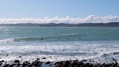 Surfing-in-Raglan,-surfers-paddling-and-waiting-for-a-wave-to-surf,-Waikato,-New-Zealand-Aotearoa