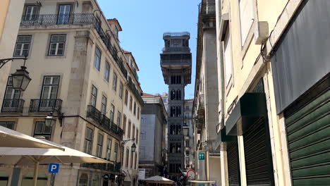 Tilt-up-of-tourist-visiting-famous-Santa-Justa-Lift-Elevator-in-Lisbon-during-sunny-day,-Portugal