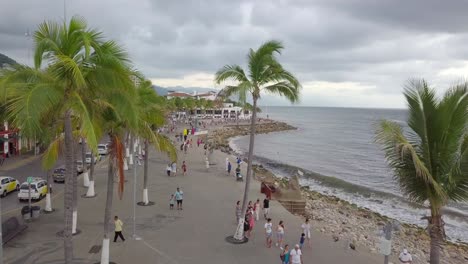 Puerto-Vallarta's-El-Malecon-Oceanfront-Promenade,-aerial-crane-shot,-cloudy-sky