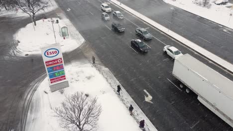 Pedestrians-take-shelter-from-a-blizzard-at-bus-stop-by-petrol-station