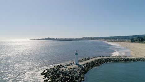 Lighthouse-on-Pier-in-Sunlight-Glistening-Water-on-the-Pacific-Coast