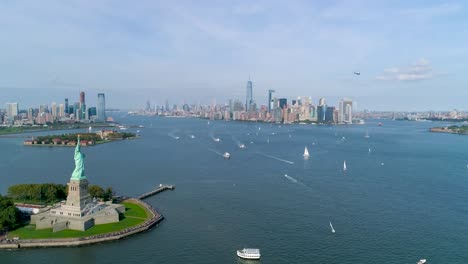 Aerial-Reverse-Dolly-of-Statue-of-Liberty-and-the-New-York-City-Skyline-with-Boats-and-Helicopter-Flyby