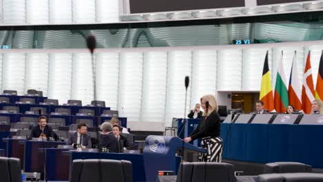 Female-politician-walking-to-the-stand-to-speech-in-the-European-Parliament-hemicycle-in-Strasbourg,-France