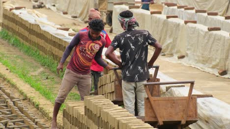 In-a-dusty-brick-field,-a-dedicated-laborer-handles-raw-bricks-with-precision,-stacking-them-into-towering-piles-with-tireless-determination-and-rugged-expertise