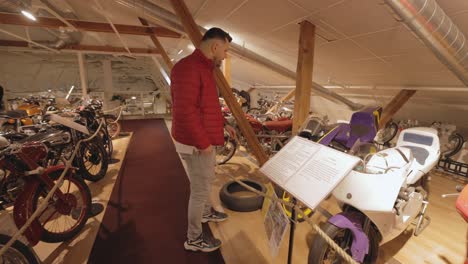 Tourist-Man-Touching-An-Old-Motor-At-Vehicle-Collection-Inside-The-Motala-Motor-Museum-In-Sweden