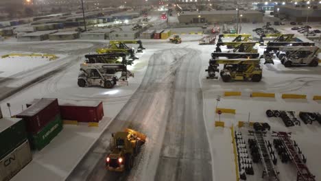Aerial-View-Of-CAT-938M-Wheel-Loader-Clearing-Snow-At-Industrial-Container-Yard-In-Brampton,-Canada