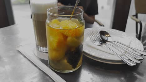 Fruit-tea-and-cream-coffe-drink-on-a-table-in-cafe,-close-up