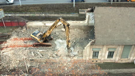 Demolition-machine-demolishing-run-down-building-into-rubble,-Czechia