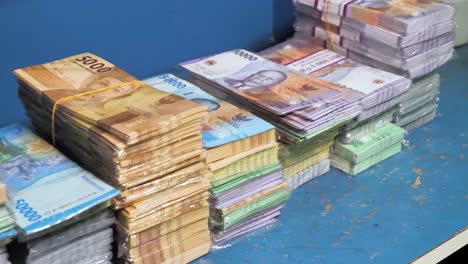 stacks-of-money-currency,-Indonesia-rupiah-stack-in-slow-motion,-different-values-of-paper-cash