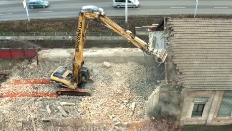 Hydraulic-arm-demolition-machine-dismantling-building-next-to-highway