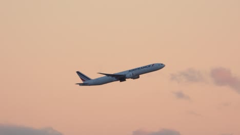 Air-France-Boeing-777-ascends-on-take-off-against-soft-pink-sky,-tracking-shot
