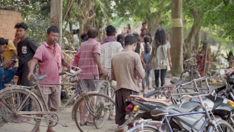 Poor-Indian-people-taking-back-their-cycles-from-parking-and-returning-back,-slow-motion