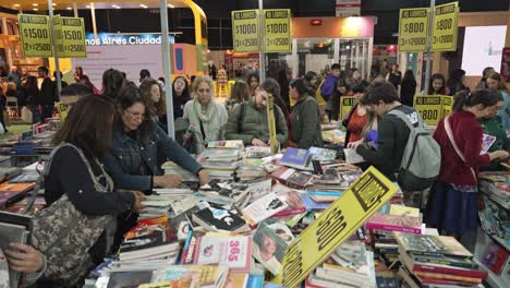 Special-discount-booth-of-cheap-books-at-messy-crowded-table-in-fair
