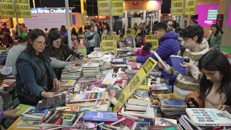 Rising-jib-over-crowds-of-people-gazing-searching-for-books-on-messy-table