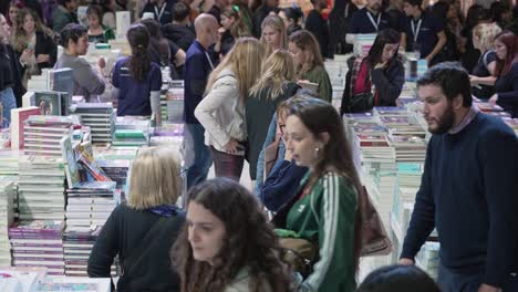Static-high-angle-looking-down-across-crowded-row-of-people-looking-for-books-at-fair