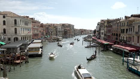 Ein-Filmischer-Blick-Auf-Den-Canal-Grande-Von-Der-Rialtobrücke-In-Venedig,-Wo-Boote-Auf-Dem-Kanal-Fahren