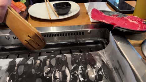 Young-woman-turns-on-a-barbecue-at-a-Korean-restaurant-in-the-Pijp-in-Amsterdam