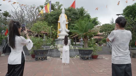 A-Tourist-Taking-Photos-Of-The-White-Statue-Of-The-Deity-Quan-Am-In-Van-Son-Pagoda-In-Con-Dao,-Vietnam