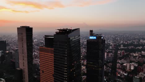 Drone-shot-circling-around-the-Ritz-Carlton-tower,-colorful-dusk-in-Mexico-city