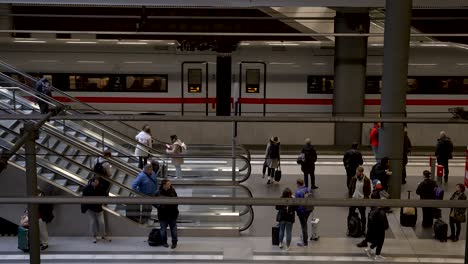 Con-Vistas-A-Los-Viajeros-Esperando-En-El-Andén-De-Nivel-Inferior-En-La-Estación-Central-De-Berlín-Con-El-Tren-De-Hielo-Db-Saliendo-En-Segundo-Plano.