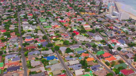 Establish-aerial-shot-of-Cape-Town-city,-colorful-residential-houses-and-clean-road,-Aerial-camera-moving-forward-neighborhood-amid-autumn-trees-at-dawn,-aerial-view