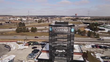 Sales-building-of-Carvana-with-vissible-cars-inside,-aerial-drone-view