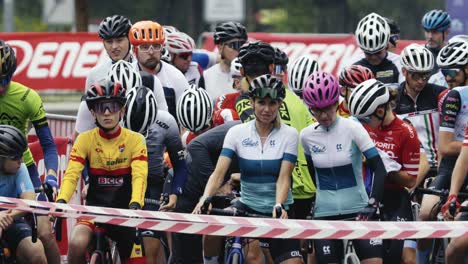Zeitlupenaufnahme-Einer-Gruppe-Männlicher-Und-Weiblicher-Rennfahrer,-Die-Auf-Den-Start-Eines-Straßenradrennens-Warten