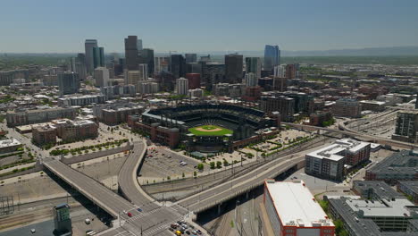 Downtown-Denver-Coors-field-Colorado-Rockies-baseball-stadium-Rocky-Mountain-landscape-14ers-Mount-Evans-aerial-drone-cinematic-foothills-Colorado-cars-traffic-spring-summer-forward-movement