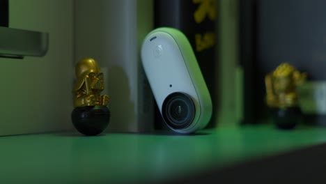Close-Up-View-Of-Insta360-GO-3-Resting-On-Shelf-Bathed-In-RGB-Lighting