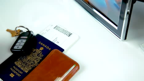Woman-Picks-up-Canadian-Passport-with-Boarding-Pass,-Keys,-and-Wallet---At-24-fps