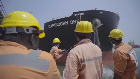 Men-At-Work-Pulling-Mooring-Line-Of-A-Huge-Cargo-Ship-At-The-Port-Of-Paradip-In-India