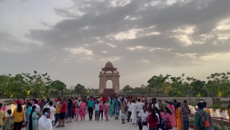 Gente-En-El-Monumento-Nacional-A-La-Guerra-Con-Dosel-Y-La-Puerta-De-La-India-Al-Fondo-En-Nueva-Delhi,-India