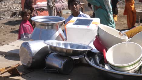 Stapel-Von-Metallschüsseln,-Trinkbechern-Auf-Dem-Tisch-Draußen-Im-Lager-Für-Flutopfer-In-Sindh