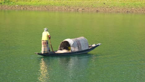 Traditioneller-Bangladeschischer-Fischer-Auf-Einem-Sampan-Boot,-Der-Das-Fischernetz-Zu-Wasser-Wirft