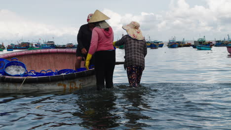 At-Mui-Ne-beach,-fishermen-offload-fresh-catch-and-hand-it-to-local-women