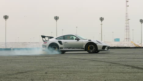 Sports-car-spinning-around-doing-donuts-with-lots-of-smoke-on-a-race-track-in-slow-motion