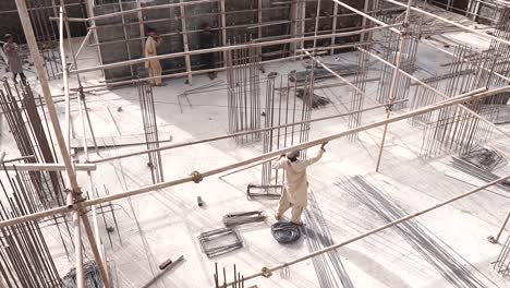 Trabajador-Llevando-Un-Poste-De-Andamio-En-Un-Sitio-De-Construcción-En-Karachi