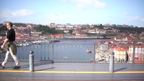Porto,-Portugal,-March-26,-2023:-Tourist-man-walking-though-San-Luis-I-bridge-crossing-Douro-river-in-Oporto,-Portugal