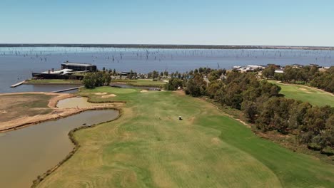 Yarrawonga,-Victoria,-Australia---3-March-2023:-Aerial-over-the-finishing-hole-and-billabong-at-the-golf-course-with-hotel-in-the-background