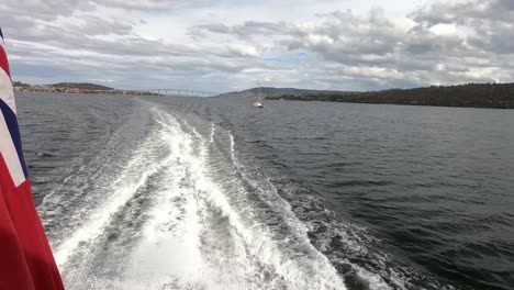 Hobart,-Tasmania,-Australia---13-March-2019:-View-from-boat-powering-down-the-Derwent-River-in-Hobart-with-Tasman-Bridge-in-background