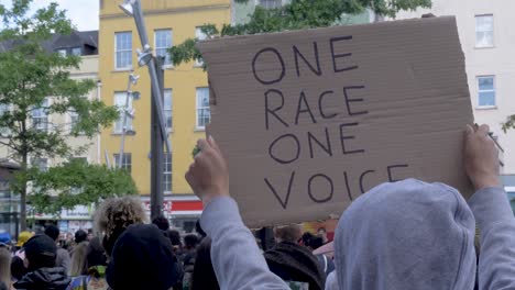 Person-rises-a-One-Race-One-Voice-Sign-on-a-Black-Lives-Matter-Protest