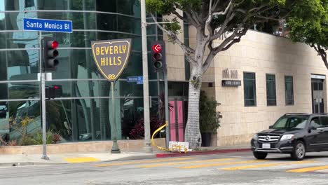 Cars-driving-on-Santa-Monica-Boulevard-with-road-sign-for-Beverly-Hills