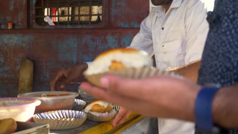 Street-side-small-independent-eatery-selling-tasty-and-spicy-streetfood-Vada-Pav-to-customer