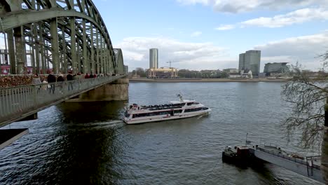Sightseeing-River-Boat-Passing-Under-Hohenzollern-Bridge-Across-The-River-Rhine-In-Cologne